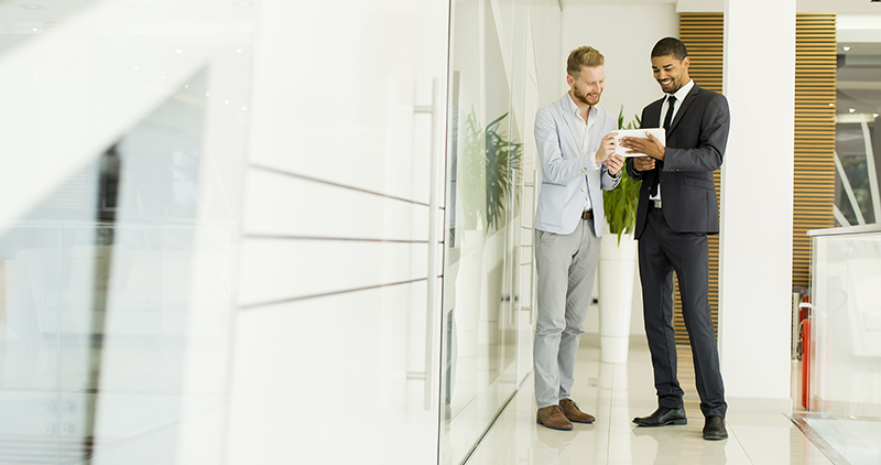 Two male agents using iPad